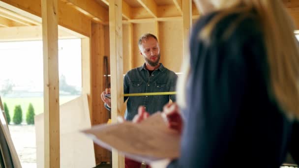 Due giovani discutono la costruzione di una casa — Video Stock