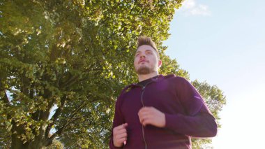 Genç adam yolda koşuyor.