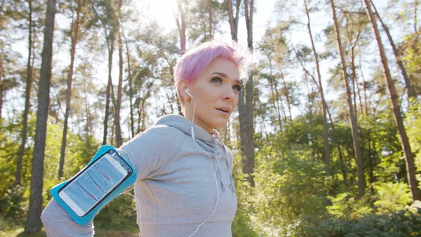 Joven dama con el pelo rosa corriendo en el bosque — Foto de Stock