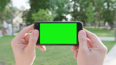 Yeşil bir ekran ile bir telefon Holding eller
