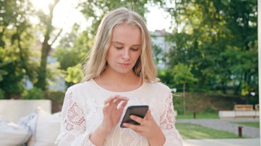 Genç sarışın Bayan kasabada bir telefon kullanma