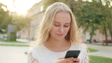 Genç sarışın Bayan kasabada bir telefon kullanma