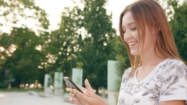 Genç Bayan kullanma şehir yürüyüş sırasında bir telefon