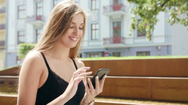 Genç Bayan kullanma şehir yürüyüş sırasında bir telefon