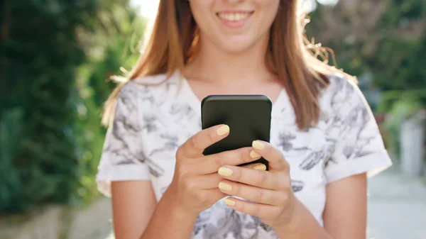 Young Lady Using a Phone in Town while Walking — Stock Photo, Image