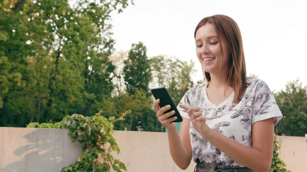 Young Lady Using a Phone in Town while Walking — Stock Photo, Image