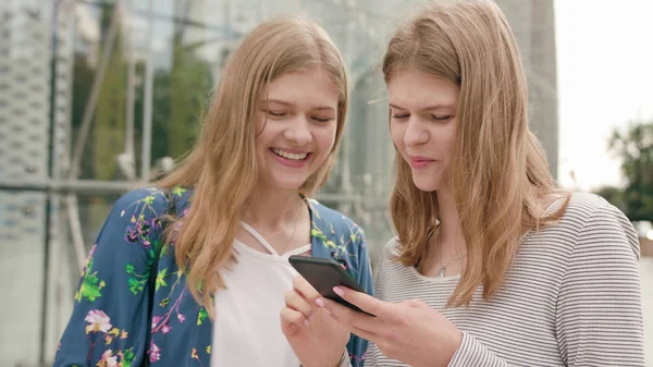 Девушки с помощью телефона в городе — стоковое фото