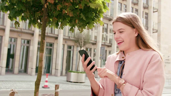 Jovencita usando un teléfono en la ciudad — Foto de Stock