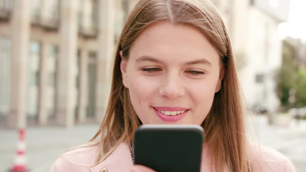 Jovencita usando un teléfono en la ciudad — Foto de Stock