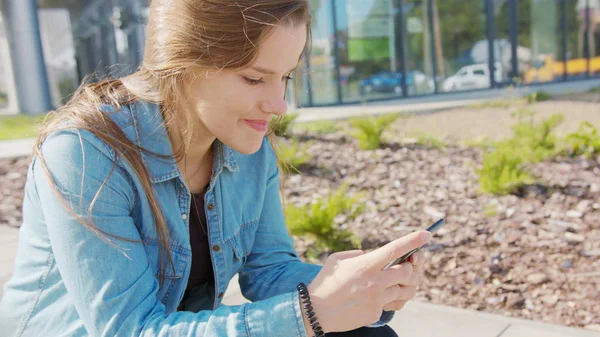 Jovencita usando un teléfono en la ciudad — Foto de Stock