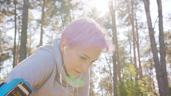 Joven dama con el pelo rosa corriendo en el bosque — Foto de Stock