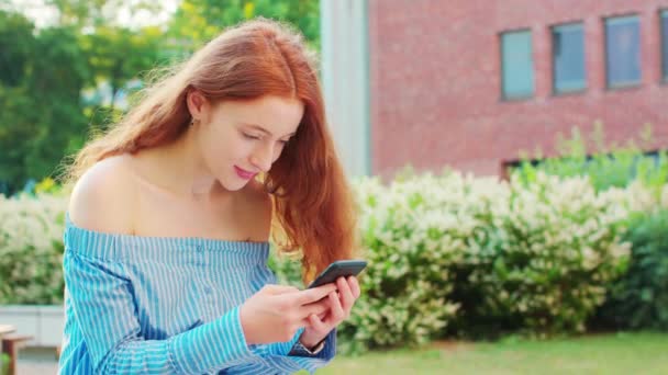 Dame utilisant un téléphone en plein air — Video