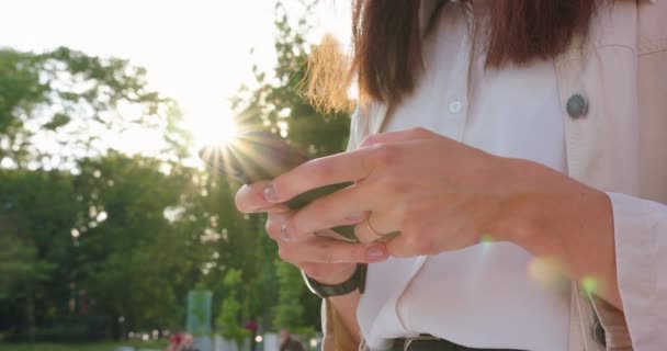 Dame utilisant un téléphone en plein air — Video