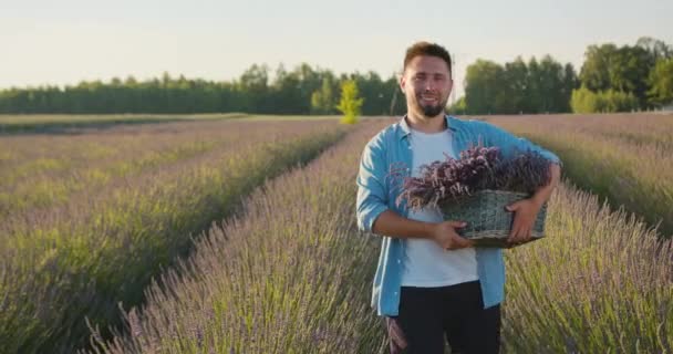 Młody człowiek w polu błękitnych kwiatów — Wideo stockowe