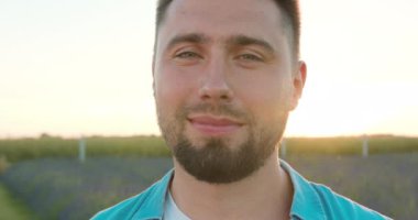 Mavi Çiçekler Alanında Genç Adam Gülümsüyor