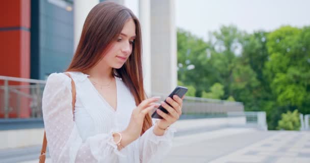 Signora utilizzando un telefono all'aperto — Video Stock