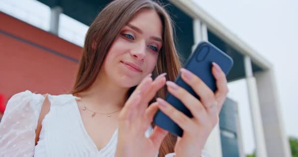 Дівчина використовує телефон на відкритому повітрі — стокове відео