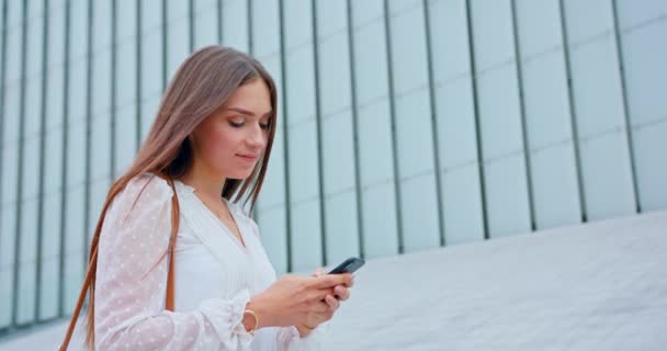 Signora utilizzando un telefono all'aperto — Video Stock