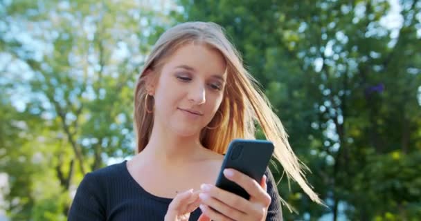 Dame utilisant un téléphone en plein air 