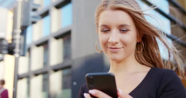 Дівчина використовує телефон на відкритому повітрі — стокове відео