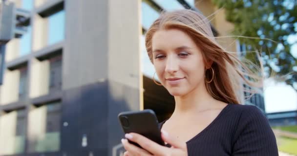 Signora utilizzando un telefono all'aperto — Video Stock