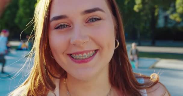 Jovencita sonriendo al aire libre. Emoción — Vídeo de stock