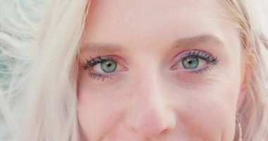 Sarışın bayan dışarıda gülümsüyor.