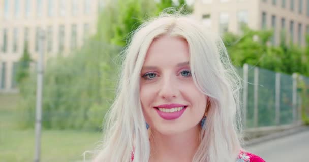 Jonge blonde dame glimlachen buiten — Stockvideo