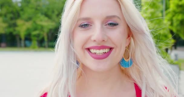 Jeune blonde dame souriant en plein air — Video