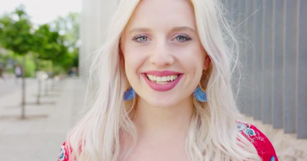 Junge blonde Dame lächelt im Freien — Stockvideo