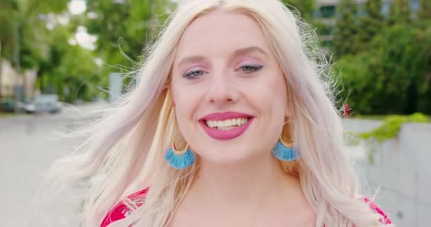 Junge blonde Dame lächelt im Freien — Stockvideo