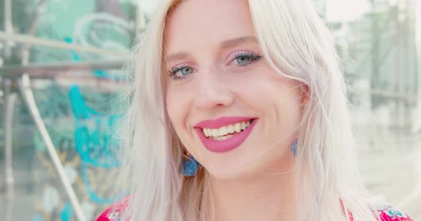 若いブロンドの女性は屋外で微笑む — ストック動画