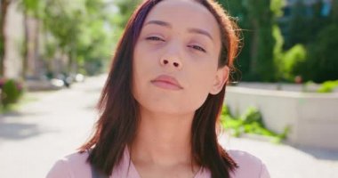 Açık havada gülümseyen esmer bayan.