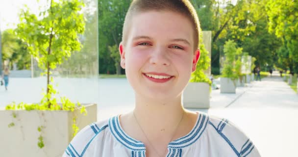 Joven mujer de pelo corto sonriendo al aire libre — Vídeos de Stock