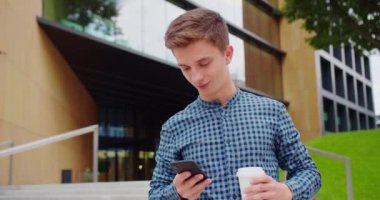 Genç adam dışarıda telefon kullanıyor.