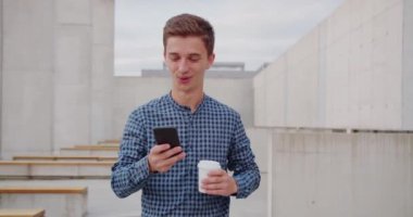 Genç adam dışarıda telefon kullanıyor.