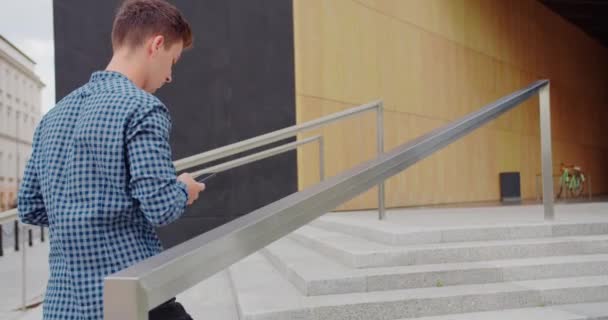 Joven usando un teléfono al aire libre — Vídeos de Stock