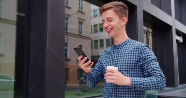 Giovane uomo utilizzando un telefono all'aperto — Video Stock
