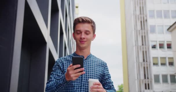 Joven usando un teléfono al aire libre — Vídeos de Stock