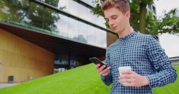 Joven usando un teléfono al aire libre — Vídeos de Stock