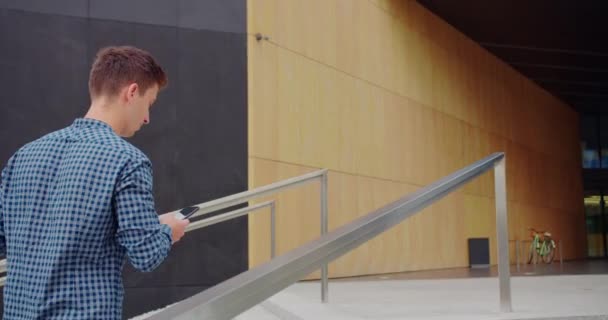 Joven usando un teléfono al aire libre — Vídeos de Stock