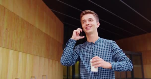 Joven usando un teléfono al aire libre — Vídeo de stock