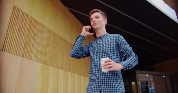 屋外で携帯電話を使う若い男 — ストック動画