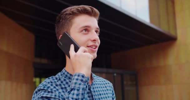 Genç adam dışarıda telefon kullanıyor. — Stok video