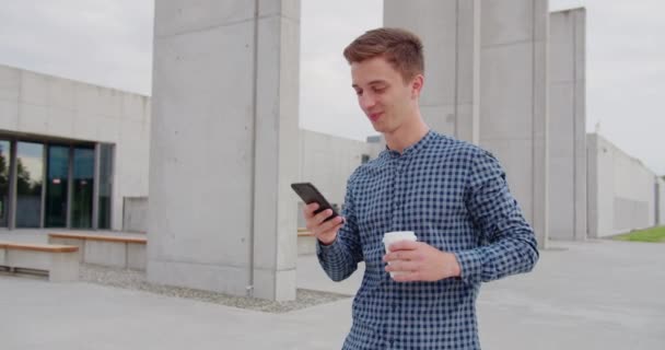 Joven usando un teléfono al aire libre — Vídeos de Stock