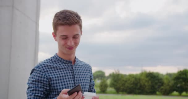 Giovane uomo utilizzando un telefono all'aperto — Video Stock