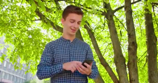 Joven usando un teléfono al aire libre — Vídeo de stock