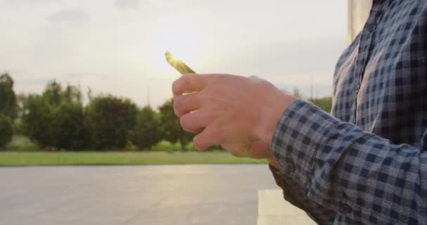 Joven usando un teléfono al aire libre — Vídeos de Stock