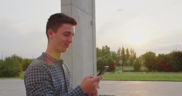 Joven usando un teléfono al aire libre — Vídeos de Stock