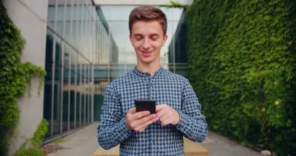 Joven usando un teléfono al aire libre — Vídeos de Stock